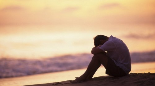 Mann ist deprimiert am Strand
