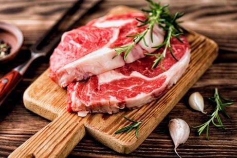 Zwei Stück rohes Fleisch auf einem Holzbrett.