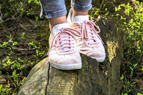 Turnschuhe balancieren auf einem Baumstamm
