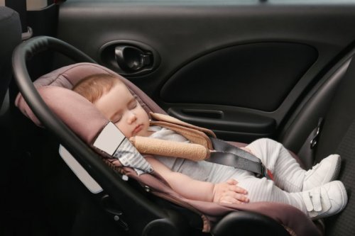 Kind schläft im Autositz