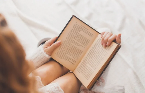 Eine Frau liest ein Buch, um ihre Sprachgewandtheit verbessern zu können.