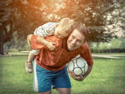 Vater und Sohn spielen mit einem Fußball.