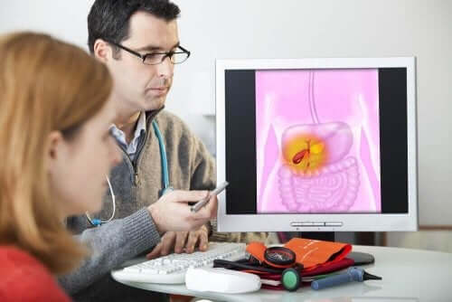 Ein Doktor erklärt einer Patientin anhand einer Abbildung am Computer, wie die Gallenblase und Leber funktionieren.