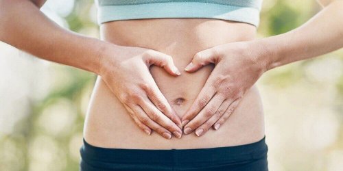 Eine Frau hält sich beide Hände an den Bauch.