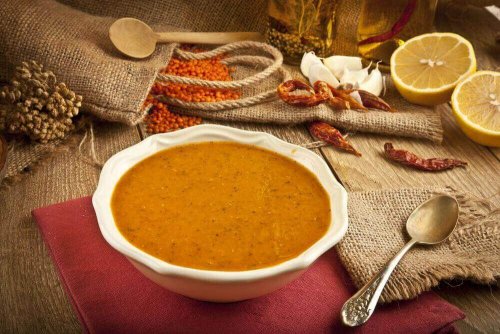 Auf einem Tisch steht ein Teller mit Linsensuppe.