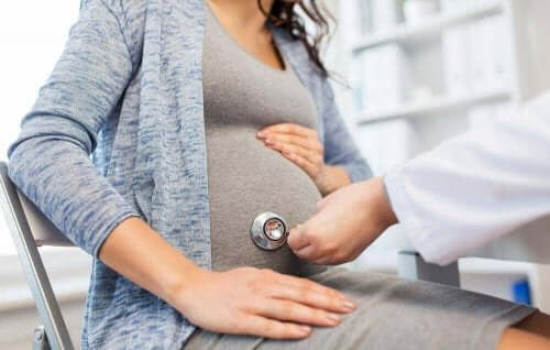 Eine schwangere Frau ist bei einer ärztlichen Untersuchung und benötigt die Unterstützung der Familie in der Schwangerschaft.