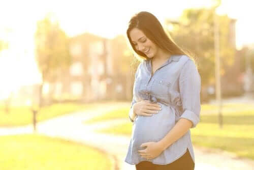 Eine schwangere Frau geht draußen spazieren.
