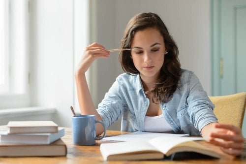 Junge Frau sitzt am Tisch und lernt