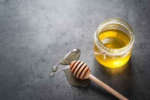 Ein Glas Honig mit Holzlöffel