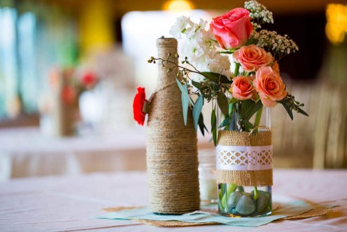 Flaschen mit Blumen als Tischdekoration