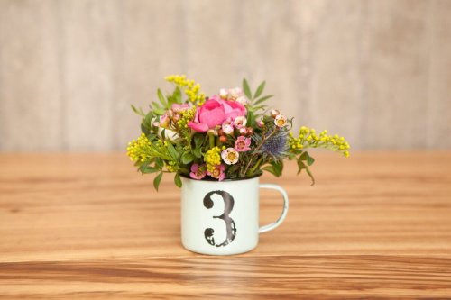 Blumen in der Tasse als Tischdekoration
