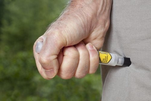 Eine Person setzt sich eine Epinephrin-Spritze
