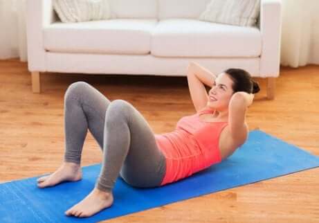 Frau macht Sit-ups auf Matte