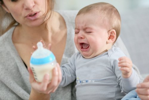 Weinendes Baby mit Fläschchen