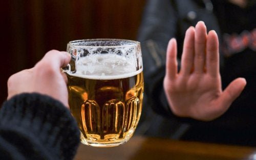 Alkoholabhängigkeit: Jemand lehnt ein Glas Bier ab