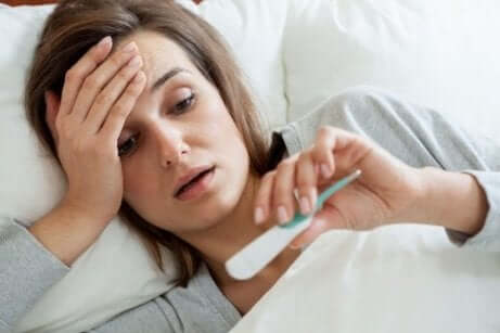 Frau mit Fieber im Bett