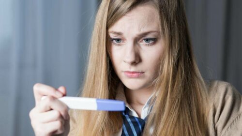 Frau blickt auf einen Schwangerschaftstest