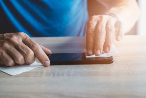 Verwende Desinfektionstücher, um eine Ansteckung mit dem Coronavirus durch das Mobiltelefon zu verhindern