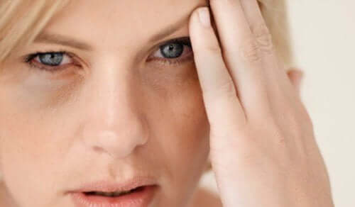 Herzinfarktsymptome - Frau mit Kopfschmerzen