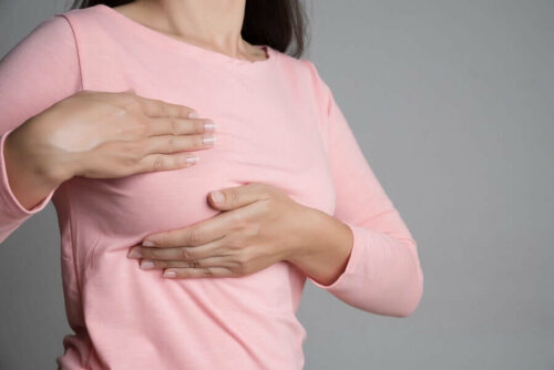 Brustschmerzen nach - Frau tastet ihre Brust ab