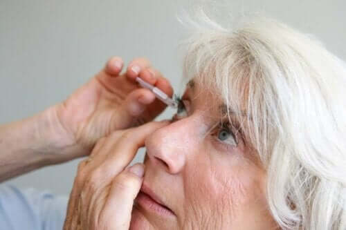 Uveitis - Frau nimmt Augentropfen
