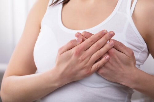 EIne Frau mit Mastitis hält sich die Brust