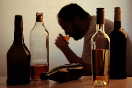 Ein Alkoholiker beim Trinken mit mehreren Flaschen