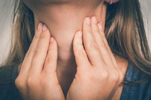 Laryngektomie - Frau fasst sich an den Hals