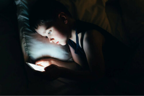 Soziale Medien - Kind nutzt Handy unter der Bettdecke
