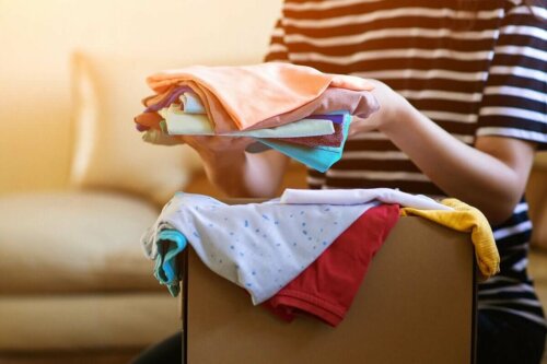 Eine Frau sortiert eine Kiste mit gespendeter Kleidung