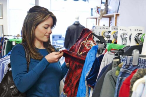 gebrauchte Kleidung kaufen - Frau überprüft ein Kleidungsstück