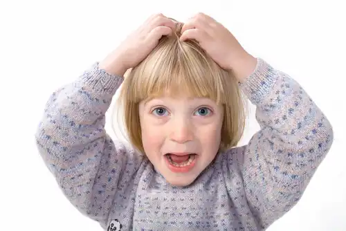 Kopfläuse loswerden - Kind kratzt sich am Kopf